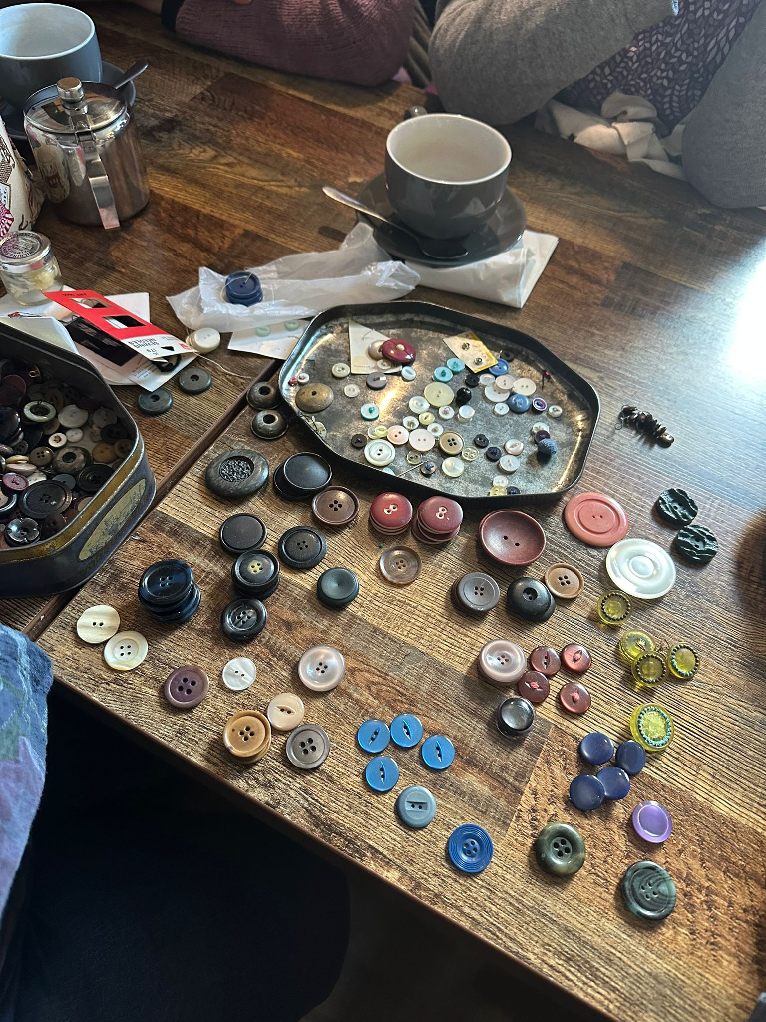 Buttons, thread and needlework laid out on the table over coffee at Coffee Craft & Chat