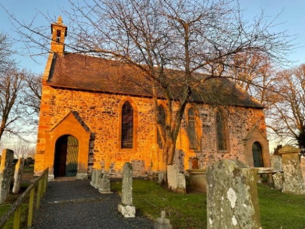 The south side of St Michael's Church, warm stone walls and arched windows lit by low winter sun